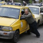 سائقو سيارات الأجرة يدفعون سياراتهم التي نفد منها البنزين إلى محطة محروقات في العاصمة السورية دمشق – 16 نيسان 2019 (AFP)